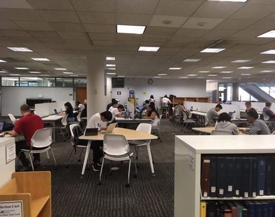 Students sit around new tables and chairs in the Hagerty Library